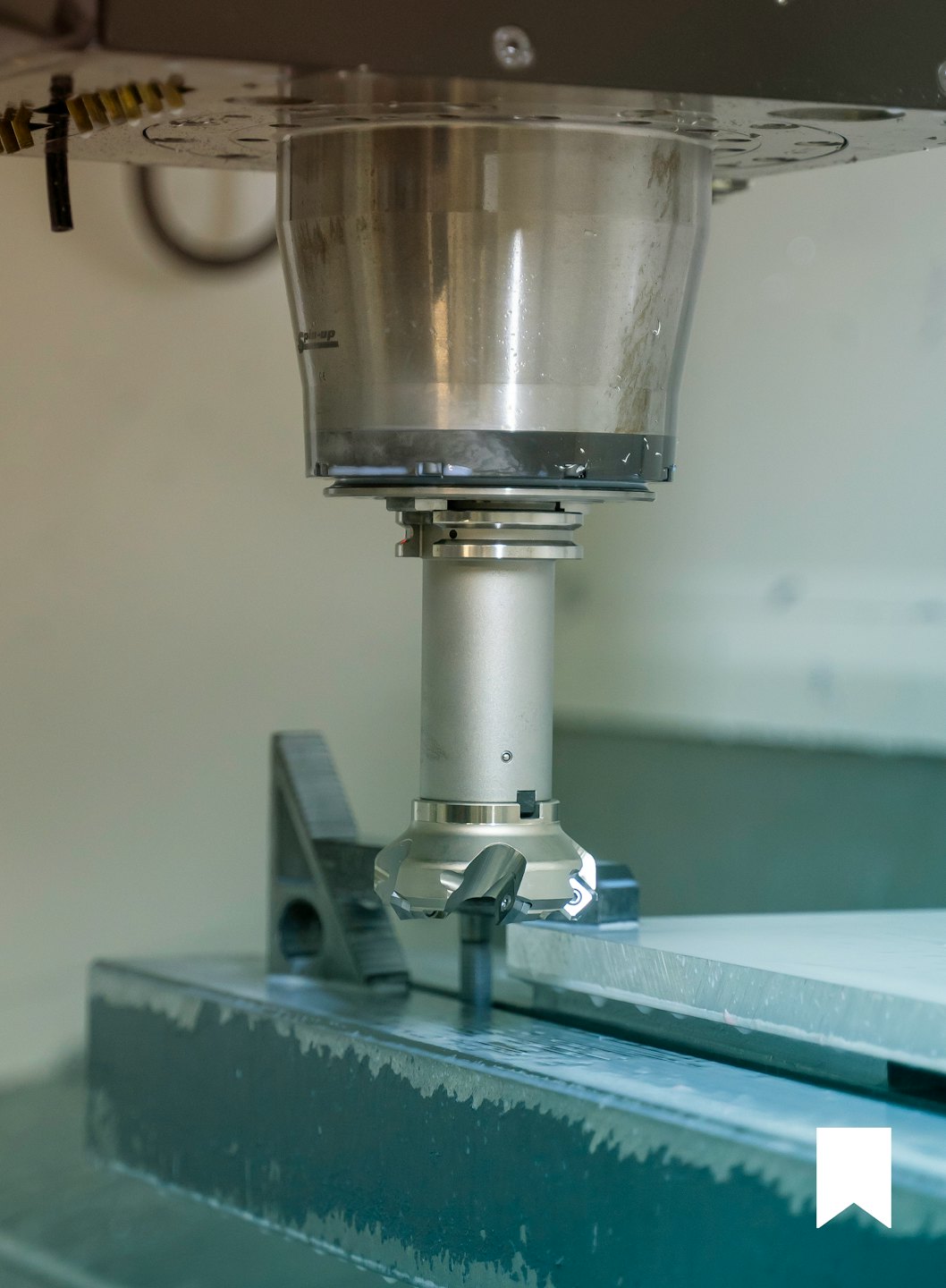 CNC-freesmachine die metaal bewerkt met koelvloeistof.