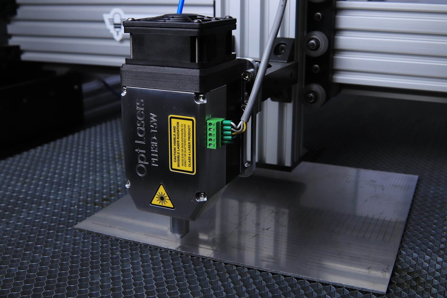Lasergraveerder die lijnen aanbrengt op geborsteld metalen oppervlak.